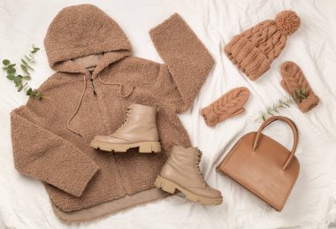 Beyaz çarşaf ve üst manzara üzerinde kadınların modaya uygun bahar kıyafetleriyle yatıyordu.