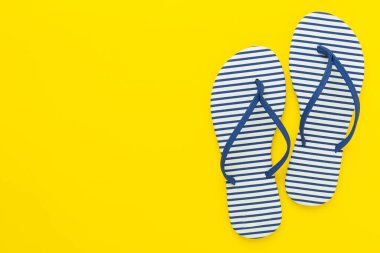 Renkli arka planda çizgili mavi parmak arası terlikler, üst görünüm