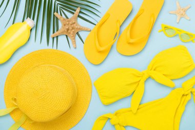 Düz yatıyordu, sarı yaz kıyafeti ve renk arka planı vardı. Tatil kavramı