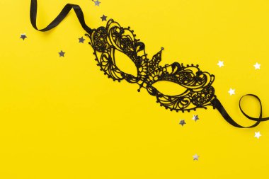 Renkli arka planda konfeti olan parlak karnaval maskesi, üst görünüm