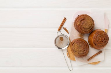 Ahşap arka planda ev yapımı tarçınlı börekler.