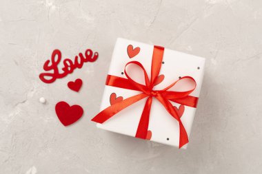 Beton zemin üzerinde kırmızı kalpler olan hediye kutuları, üst görünüm