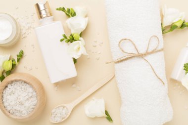 Renkli arka planda spa ürünleri ve çiçeklerle düz yatıyordu