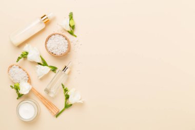 Renkli arka planda spa ürünleri ve çiçeklerle düz yatıyordu