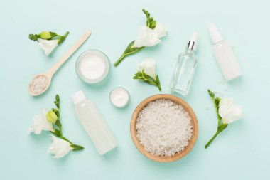 Renkli arka planda spa ürünleri ve çiçeklerle düz yatıyordu