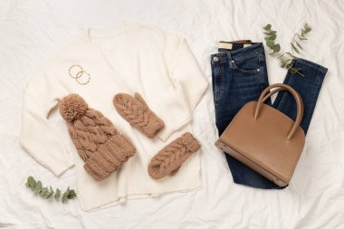 Beyaz çarşaf ve üst manzara üzerinde kadınların modaya uygun bahar kıyafetleriyle yatıyordu.