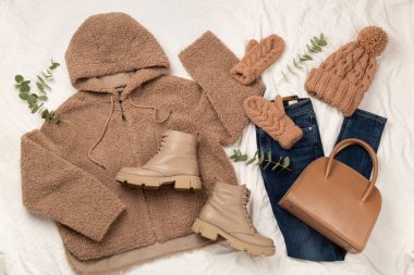 Beyaz çarşaf ve üst manzara üzerinde kadınların modaya uygun bahar kıyafetleriyle yatıyordu.