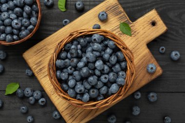 Ahşap arka planda taze yaban mersinli kase, üst manzara.