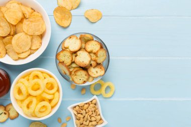 Ahşap arka planda çeşitli sağlıksız atıştırmalıklar.