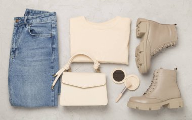 Beton arka planda modaya uygun bahar kıyafetleriyle yatıyordu.