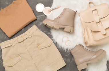 Beton arka planda modaya uygun bahar kıyafetleriyle yatıyordu.