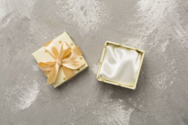 Beton zemin üzerinde bej rengi açık hediye kutusu, üst görünüm