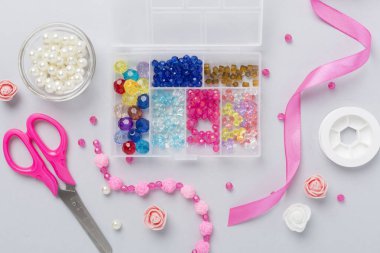 Renkli arka plan, üst görünüm üzerinde el yapımı mücevherler yapmak için araçlar ve boncuklar