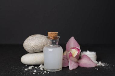 Orkideli kompozisyon, beton masadaki spa ürünleri