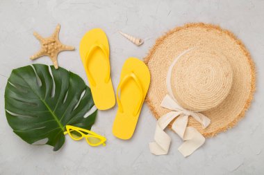 Beton arka planda renkli plaj aksesuarlarıyla yatıyordu. Tatil kavramı