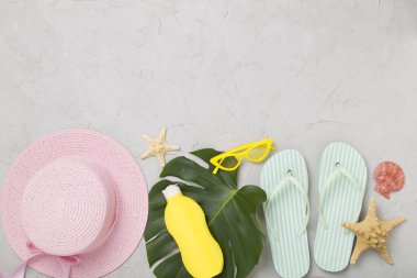 Beton arka planda renkli plaj aksesuarlarıyla yatıyordu. Tatil kavramı