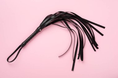 Renkli arka planda siyah kırbaç, üst manzara. BDSM konsepti