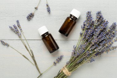 Ahşap zemin üzerinde lavanta özü olan şişeler, üst manzara.