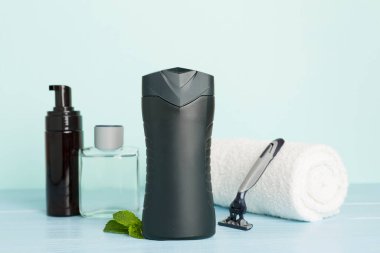 Erkekler kozmetik şişeleri ve ahşap masa üzerinde nane yaprakları.