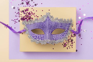 Renkli arka planda konfeti olan parlak karnaval maskesi, üst görünüm