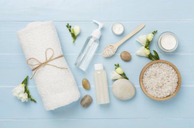 Tahta arka planda kaplıca ürünleri ve çiçeklerle yatıyordu