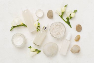 Tahta arka planda kaplıca ürünleri ve çiçeklerle yatıyordu