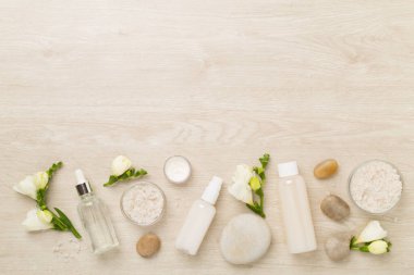 Tahta arka planda kaplıca ürünleri ve çiçeklerle yatıyordu