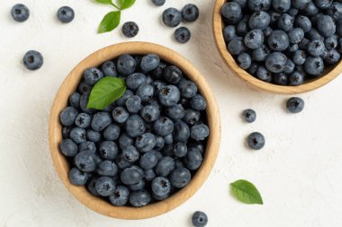 Beton arka planda taze yaban mersinli kase, üst manzara.