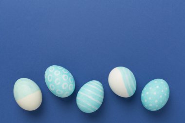 Renkli arka planda mavi paskalya yumurtaları, üst görünüm