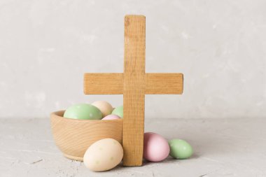 Paskalya yumurtaları ahşap haç ve beton arka plan