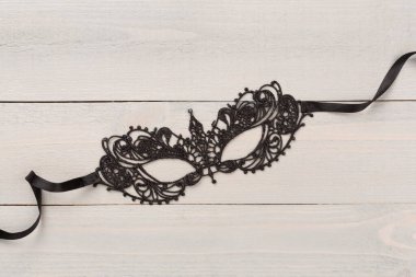 Ahşap arka planda konfetisi olan parlak bir karnaval maskesi.