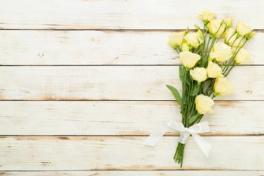 Ahşap arka planda Eustoma çiçekleri olan güzel bir buket.