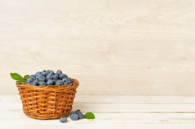 ahşap masa üzerinde taze yaban mersini ile kase