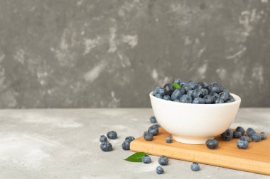 Beton arka planda taze yaban mersinli kase