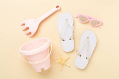 Çocuk terlikleri ve arka planda plaj oyuncakları, üst manzara.