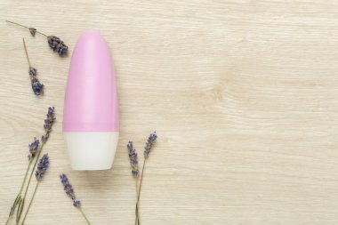 Ahşap arka planda lavanta deodorantı, üst manzara.