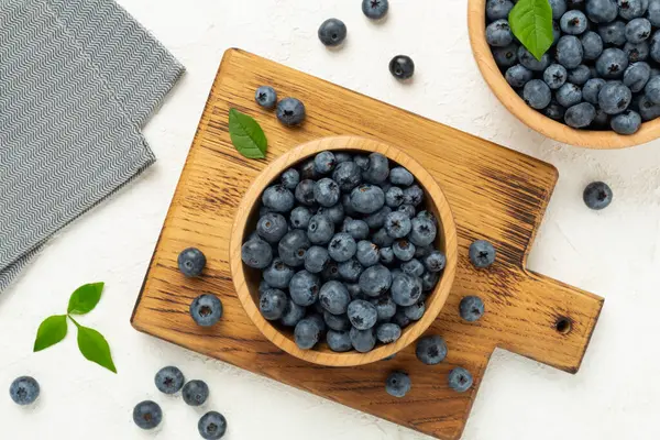 Beton arka planda taze yaban mersinli kase, üst manzara.