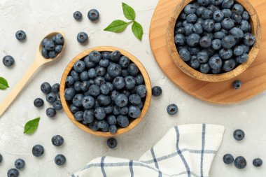 Beton arka planda taze yaban mersinli kase, üst manzara.