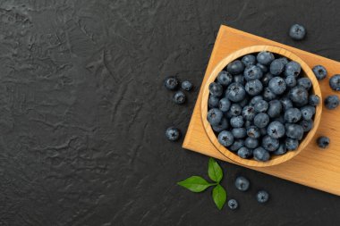 Beton arka planda taze yaban mersinli kase, üst manzara.