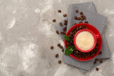 Kahve çekirdekli kahve ve çimento arka planda yapraklar.