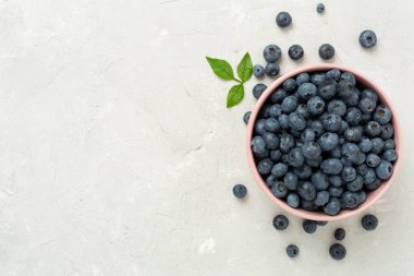 Beton arka planda taze yaban mersinli kase, üst manzara.