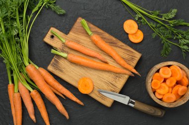 Beton arka planda dilimlenmiş taze havuçlar, üst manzara.