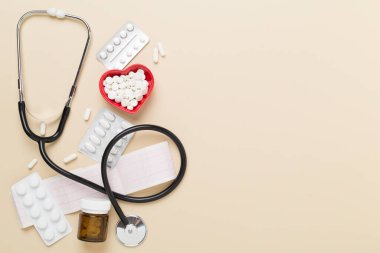 Arka planda kalp ilaçları bulunan steteskop, üst görünüm