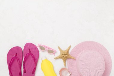 Beton arka planda renkli plaj aksesuarlarıyla yatıyordu. Tatil kavramı