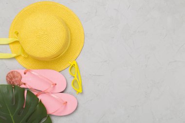 Beton arka planda renkli plaj aksesuarlarıyla yatıyordu. Tatil kavramı