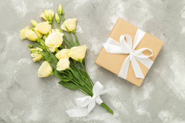 Beton arka planda güzel buketli hediye kutusu, üst manzara.