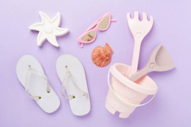 Çocuk terlikleri ve arka planda plaj oyuncakları, üst manzara.