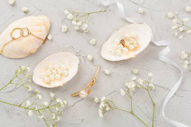 Beton arka planda dekorasyonu olan zarif altın mücevherler.