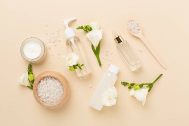 Renkli arka planda spa ürünleri ve çiçeklerle düz yatıyordu