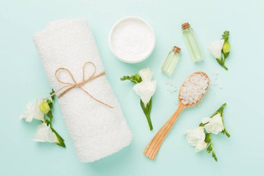 Renkli arka planda spa ürünleri ve çiçeklerle düz yatıyordu